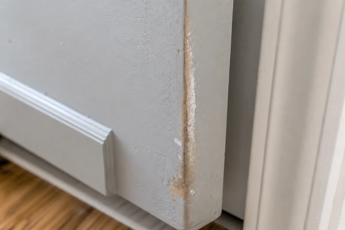 A worn rub mark on the edge of a sticking door