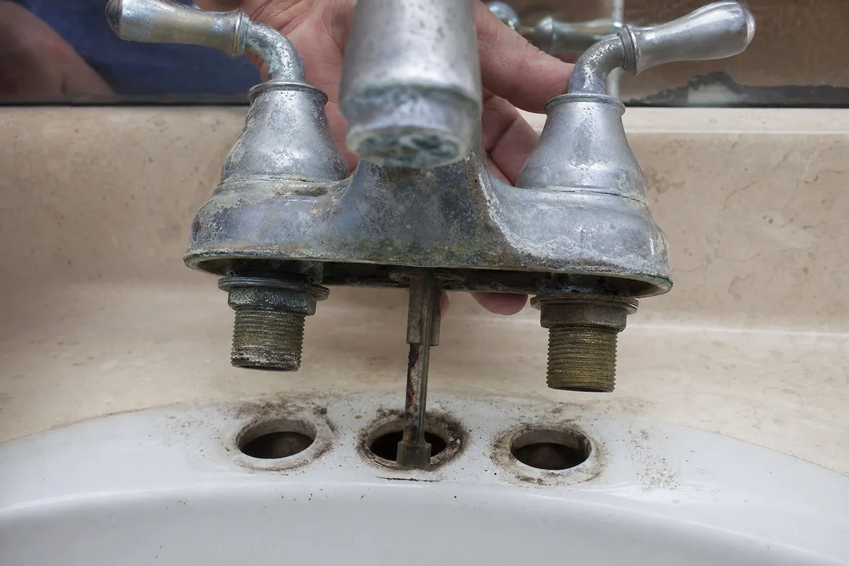 Removing an old corroded faucet from a bathroom sink